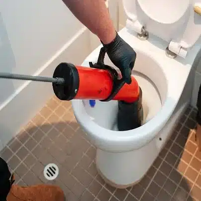 Blocked drain plumber using jet blasting for drain clearing