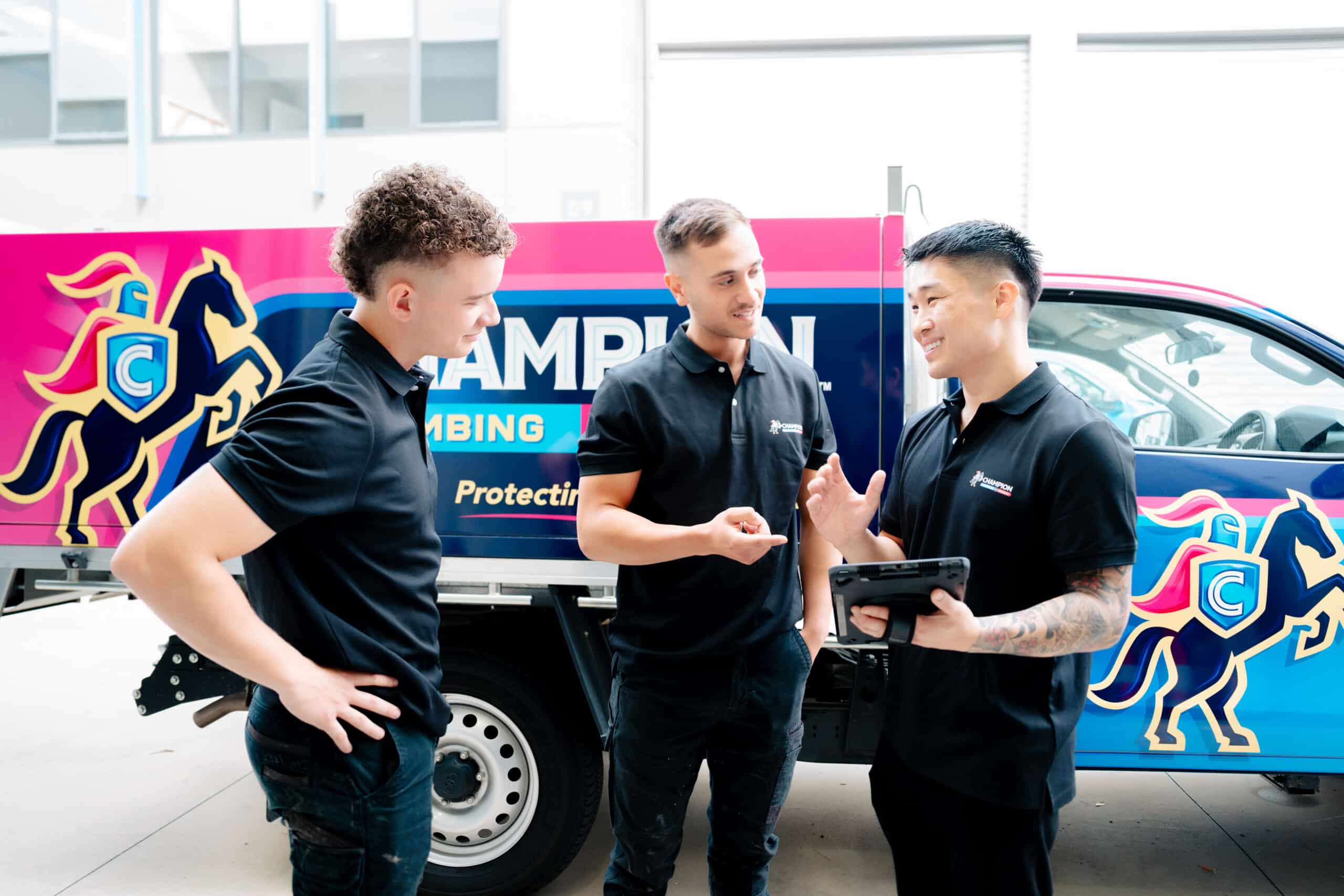 Team members standing with branded service van