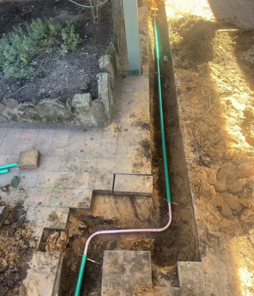 New gas service pipe laid in a trench beside a garden path to relocate the gas service in Berala