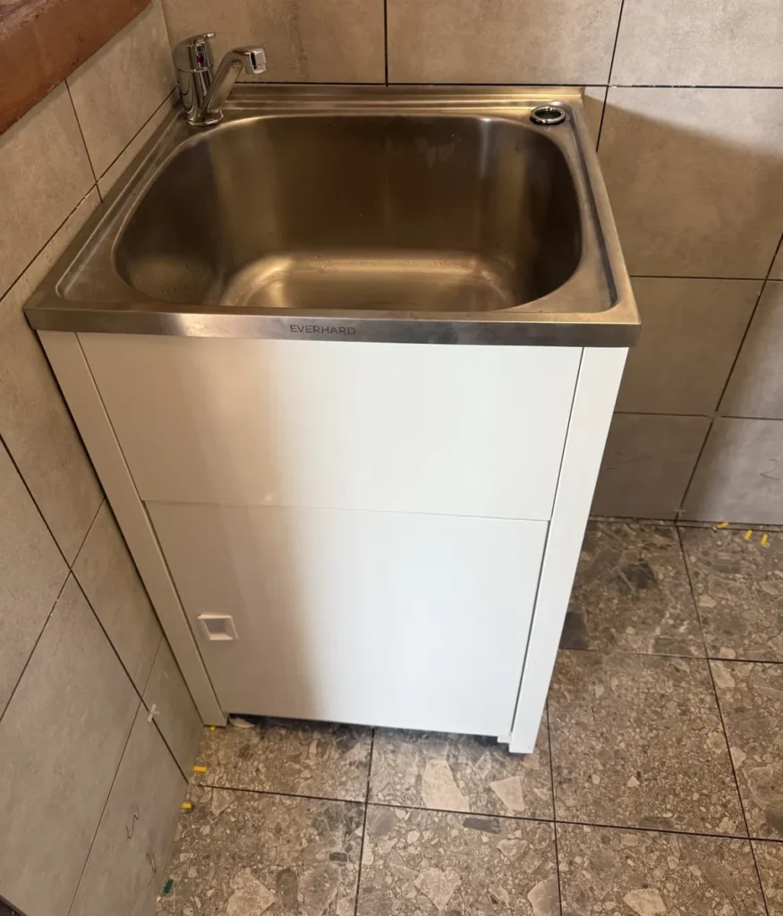 New stainless steel laundry tub and cabinet installed in a freshly renovated laundry in Petersham